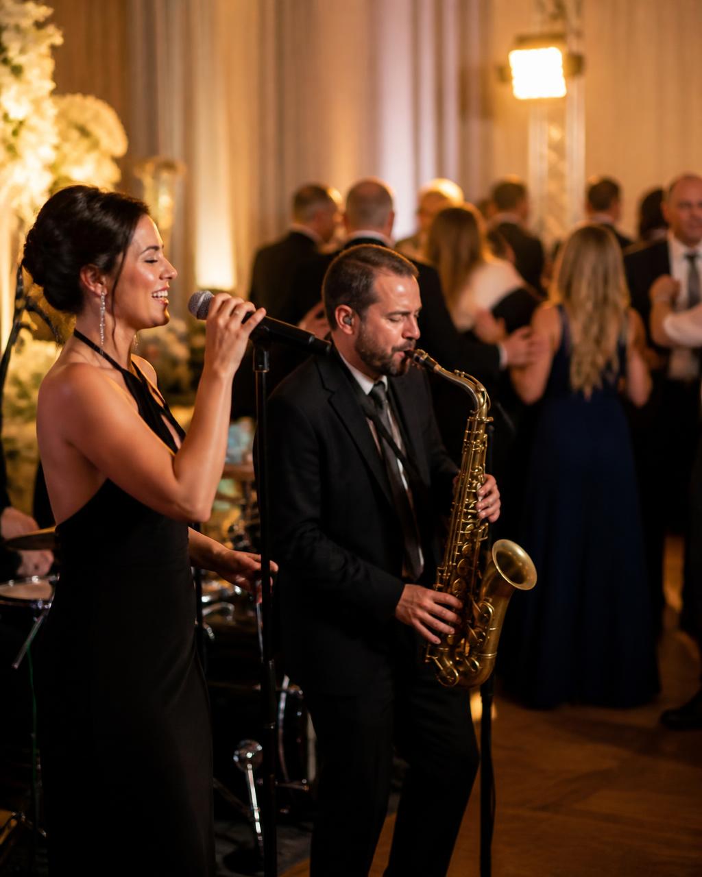 Live band with vocalist and saxophonist performing at an evening reception
