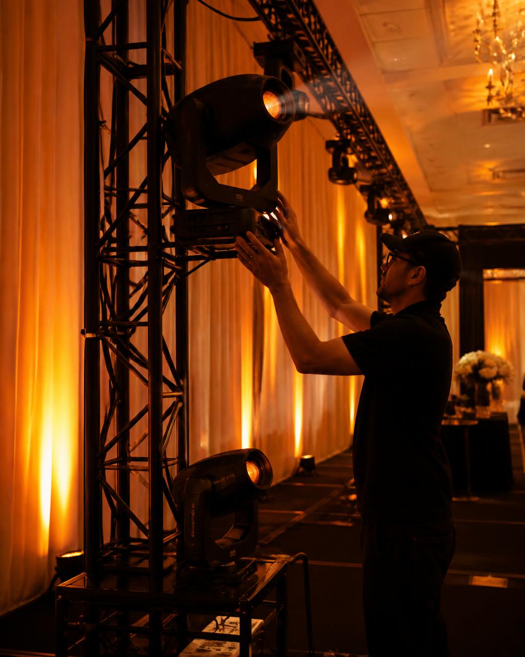Professional stage lighting and truss installed inside a draped ballroom